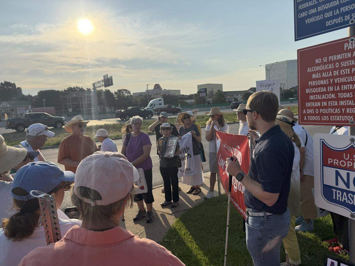 Members of a Dallas interfaith group gather outside the city’s immigration facility for a prayer vigil.