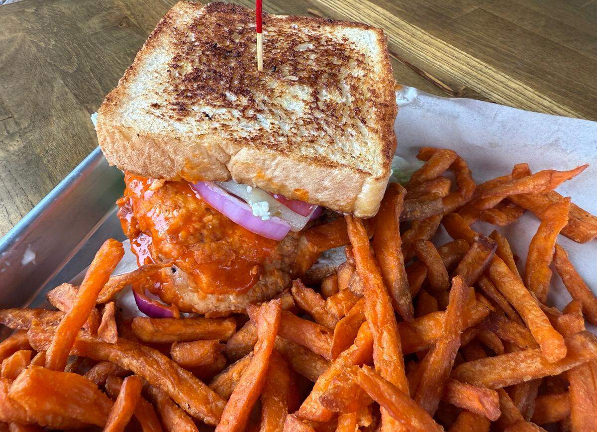 A Buffalo chicken sandwich with blue cheese and sweet potato fries at the Lakehouse on Eagle Mountain Lake in Fort Worth, Texas, May 17, 2025.