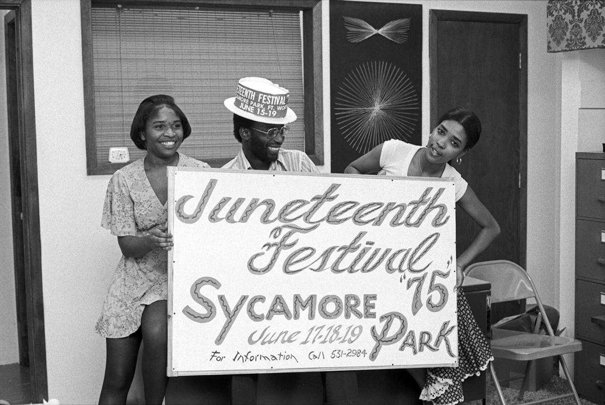 Organizers for the 1975 Juneteenth festivities to be held in Sycamore Park are seen posing with a Juneteenth Festival sign.