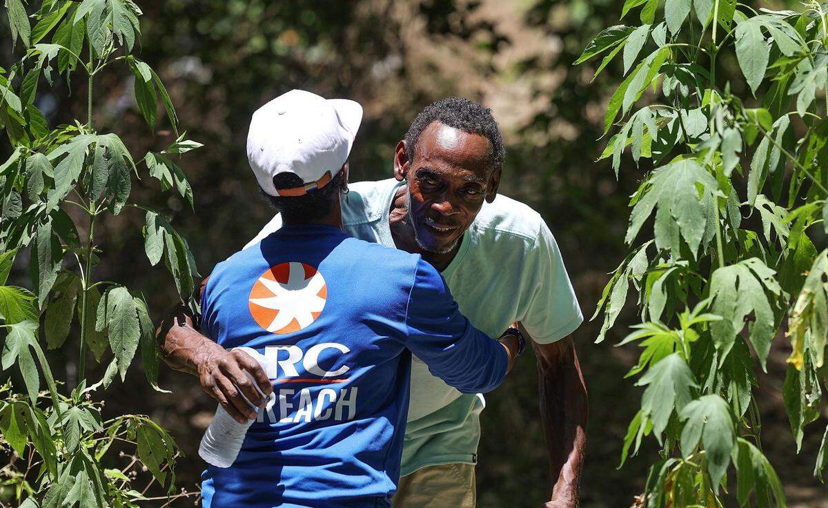 Fatimah Robertson hugs Gary Randle, 61, while working to bring water and other supplies to those living outside in the heat on Friday, June 30, 2023. Robertson says she had a special relationship with Randle, who died from suspected heat exposure in August.