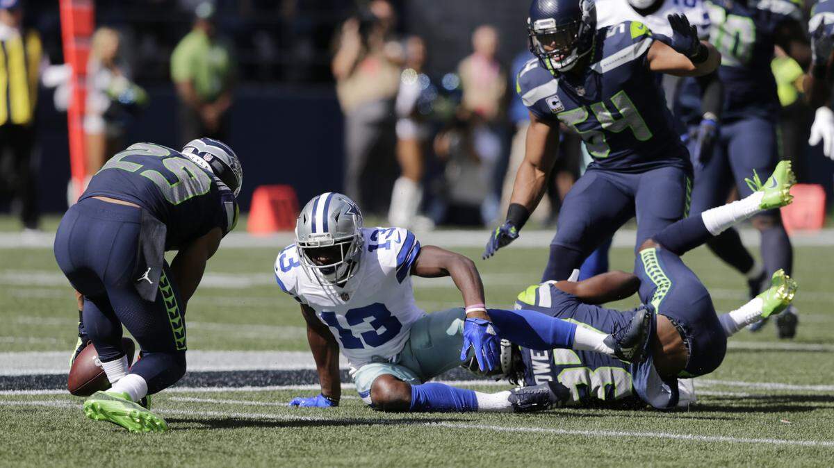 Seahawks free safety Earl Thomas, left, intercepts a pass intended for Dallas Cowboys wide receiver Michael Gallup during the first half Sunday in Seattle. The Seahawks went on to defeat the Cowboys, which drops Dallas to 1-2 on the season.