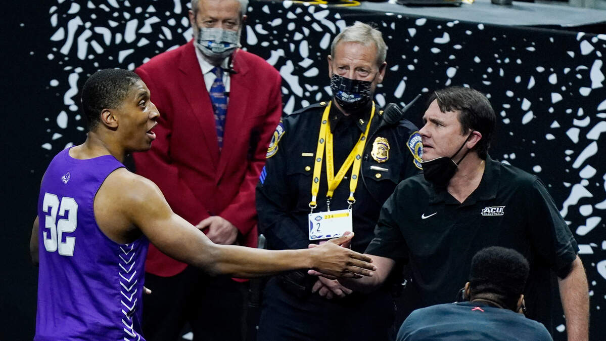 Abilene Christian head coach Joe Golding shakes hands with Joe Pleasant after stunning Texas in the NCAA Tournament on Saturday night in Indianapolis.