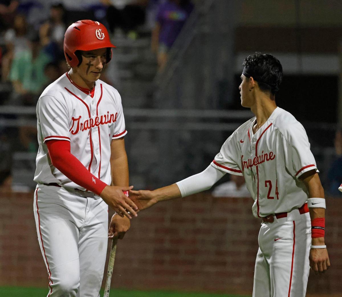 Grapevine third baseman Lale Esquivel (11) is congratulated by catcher Gianni Corral (24) after scoring during a UIL baseball game at Grapevine Mustang Field in Grapevine, Texas, Thursday, Apr. 17, 2025.