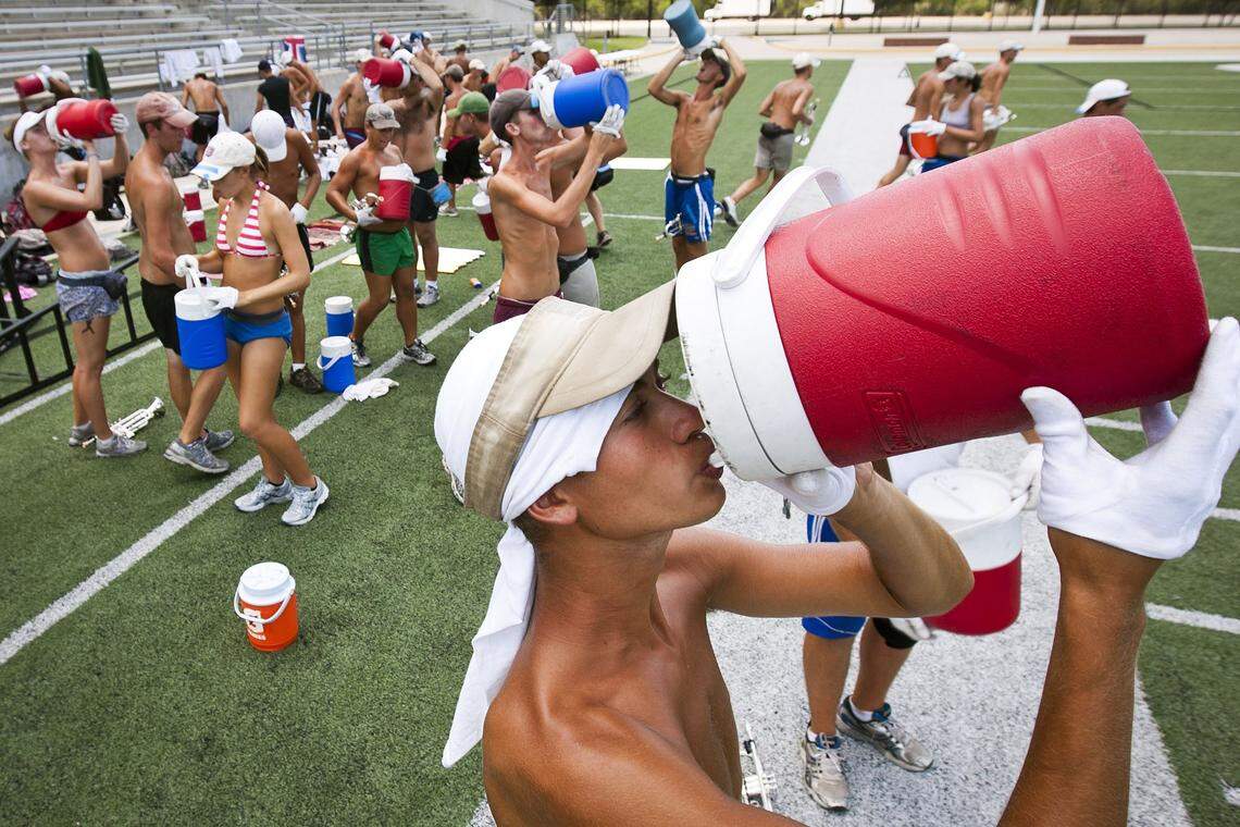 In July 2011, trumpet player Julian Johnson cools off during practice at the Berry Center football field in Cypress, Texas.