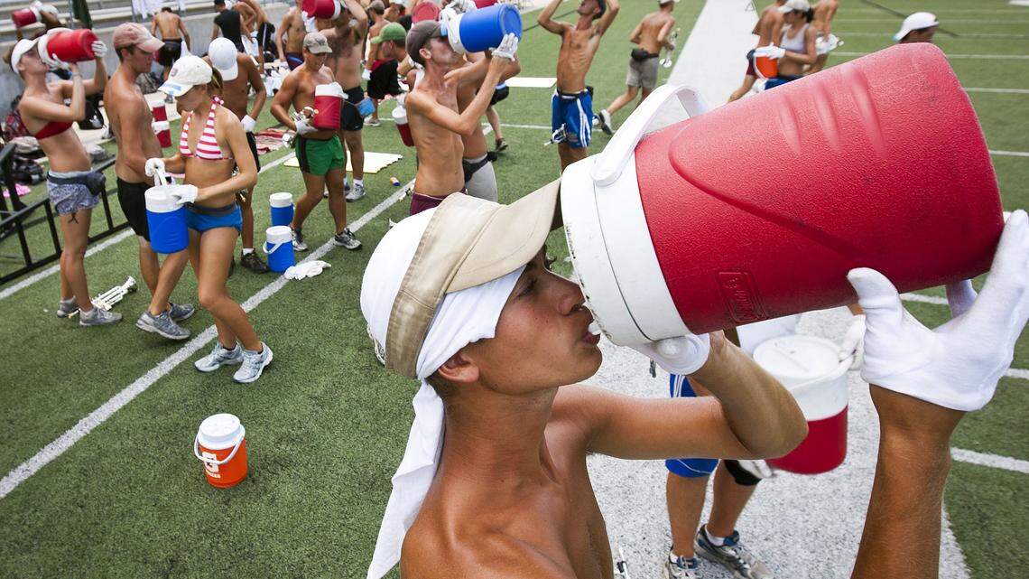In July 2011, trumpet player Julian Johnson cools off during practice at the Berry Center football field in Cypress, Texas.