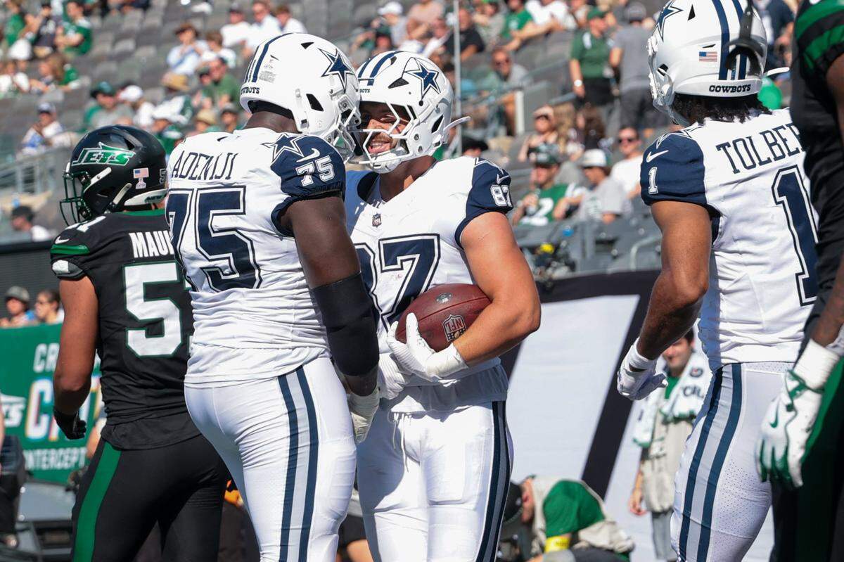 Oct 5, 2025; East Rutherford, New Jersey, USA; Dallas Cowboys tight end Jake Ferguson (87) reacts in the end zone with offensive tackle Hakeem Adeniji (75) after catching his second touchdown pass of the game against the New York Jets during the first half at MetLife Stadium. Mandatory Credit: Vincent Carchietta-Imagn Images