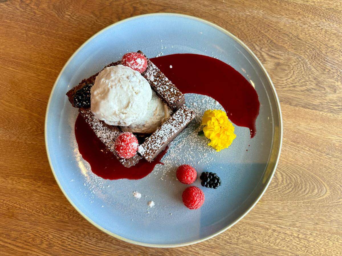 Quince’s dessert menu includes a flourless chocolate cake with cream and berries, seen Nov. 29, 2023.