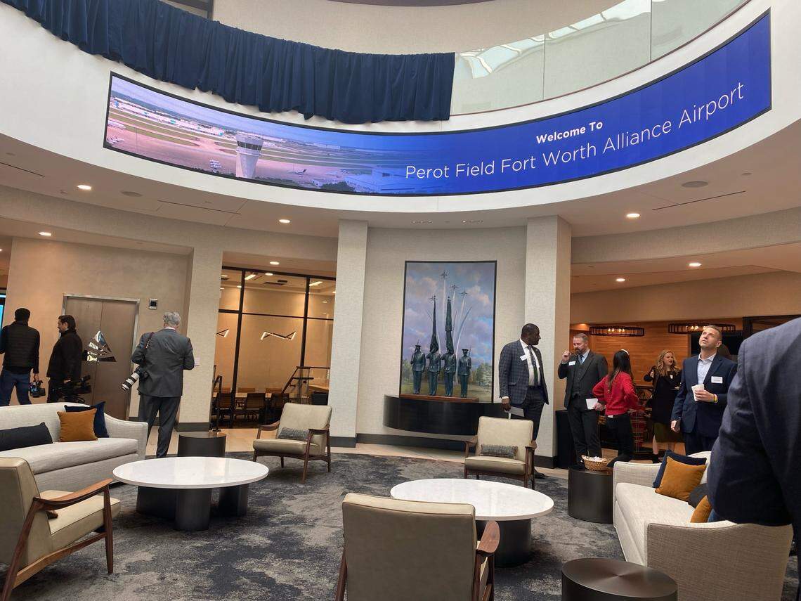 Couches and lounge chairs fill the main lounge room of Perot Field's new facility underneath a large marquee sign that reads "Welcome to Perot Field Fort Worth Alliance Airport."