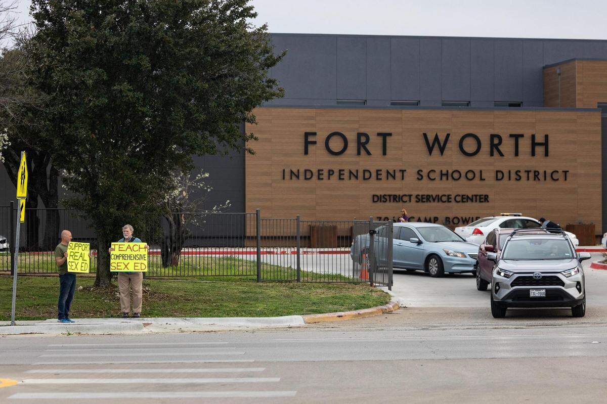 Gery Weichman, left, and former Texas state representative Lon Burnam holds signs in support of comprehensive sexual education in the Fort Worth Independent School District prior to a school board meeting at the Fort Worth ISD Administration Building on Tuesday, Feb. 27, 2024.