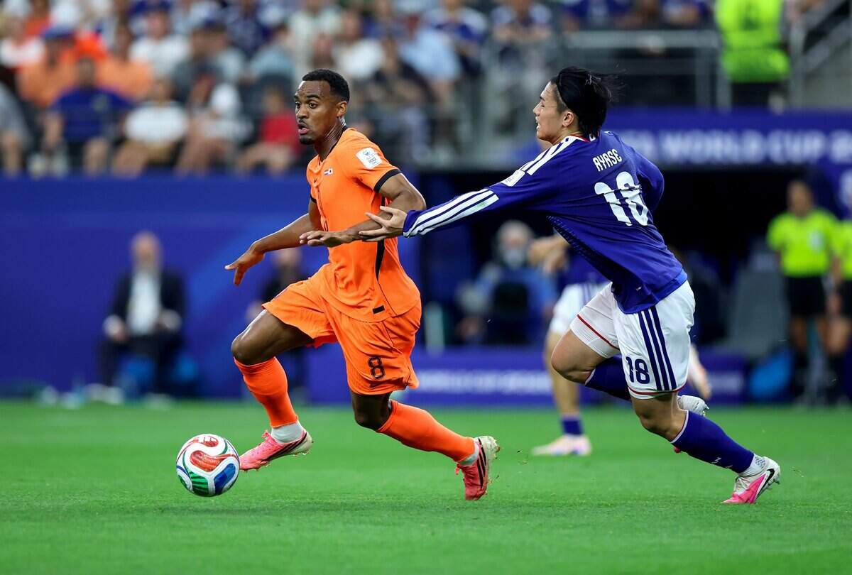 Netherland midfielder Ryan Gravenberch dribbles the ball while defended by Japan midfielder Ayase Ueda during the first half against Netherlands during a World Cup match on Sunday, June 14, 2026, at Dallas Stadium in Arlington.