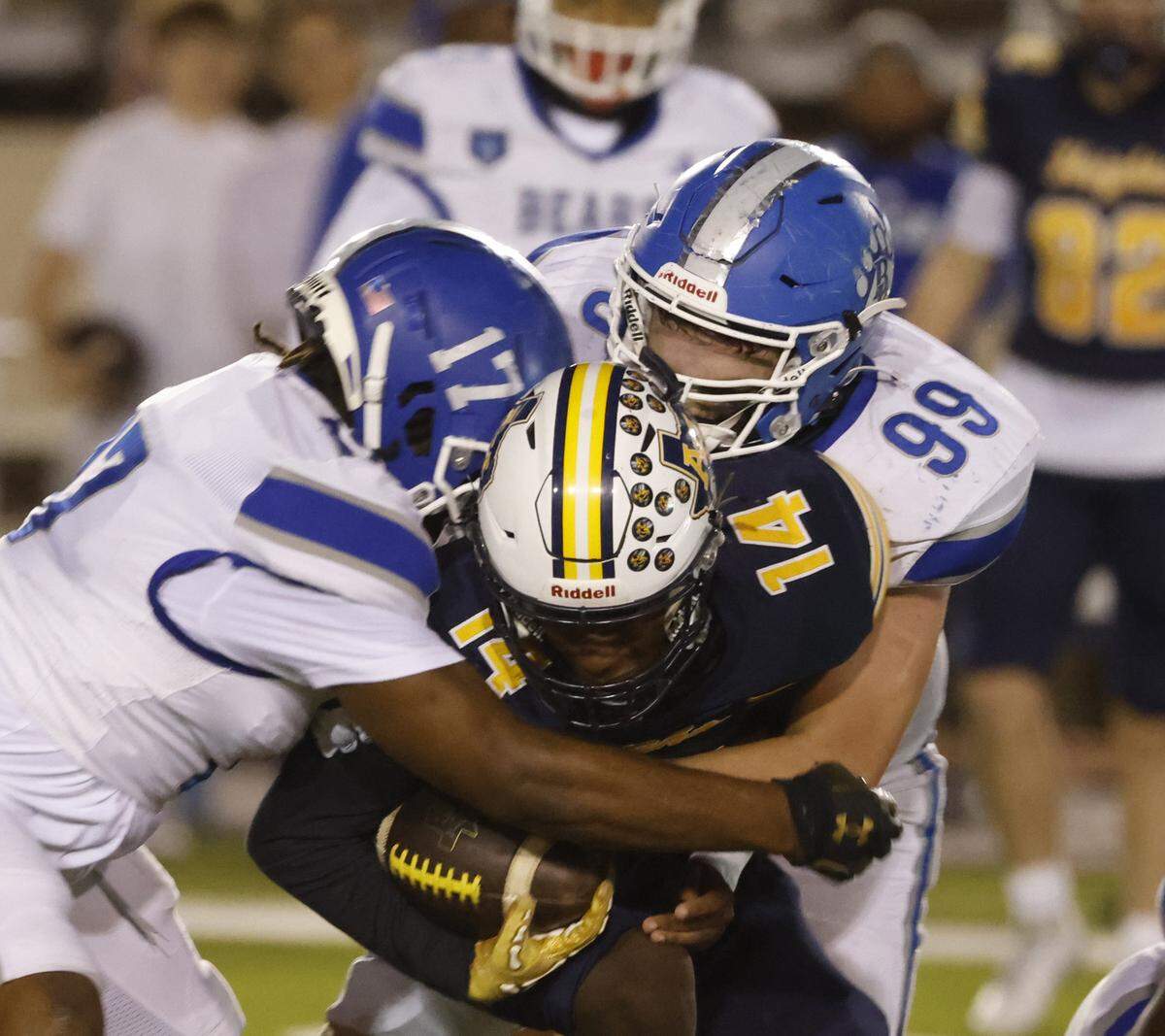 Brewer linebacker Kingston Hurst (17) and lineman Colton Clemons (99) drop Arlington Heights quarterback Carmelo Carter (14) for a loss during the first half of a UIL Conference 5A D1 Bi-District playoff game between Arlington Heights and Brewer at Farrington Field in Fort Worth, Texas, Friday, Nov. 14, 2025.