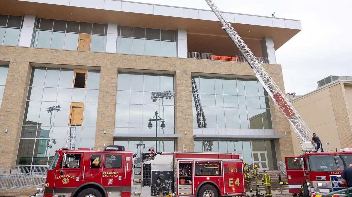 Grand Prairie Fire Department extinguishes a fire at the Grand Prairie High School. One firetruck is pictured with officers reaching the fourth floor to assess the fire.