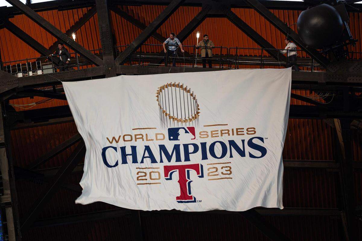 The Texas Rangers 2023 World Series Banner is unveiled in a ceremony prior to their season opener against the Chicago Cubs at Globe Life Field on Thursday, March 28, 2024.