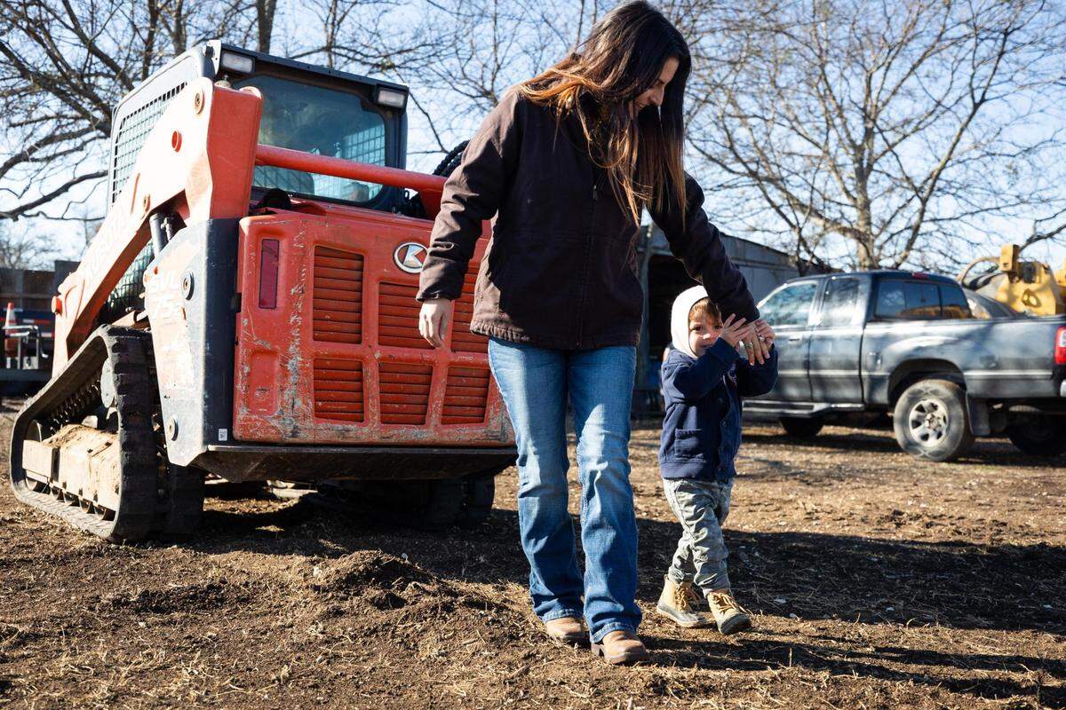 Megan White walks with Shepherd, 2, on their 85-acre family farm in Burleson. The family purchased the farm last year and is working to remove trees and brush before starting fruit and nut trees.