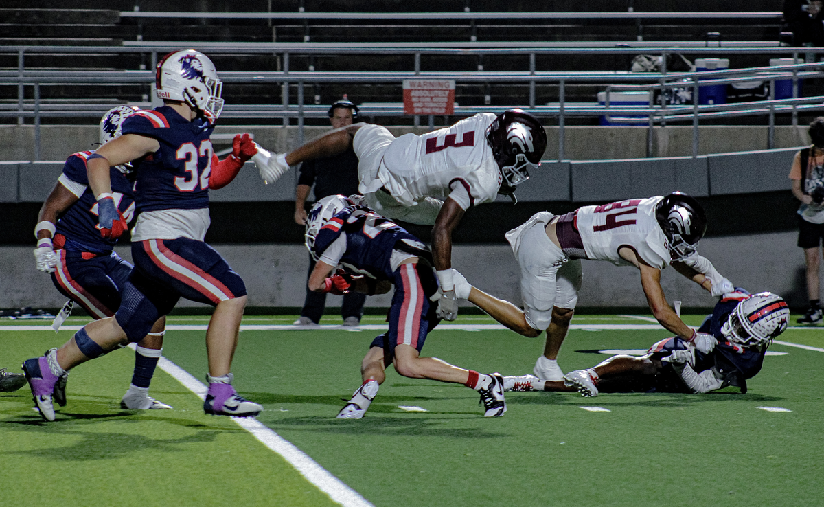 Mansfield Timberview running back Cameron Bates (3) goes airborne as Richland’s Brayden Riffle tries to take him down on Friday, October 27, 2023 at Birdville Fine Arts/Athletics Complex in North Richland Hills, Texas.
