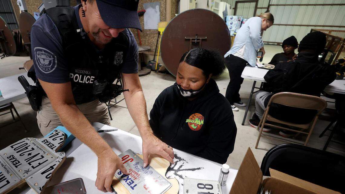 Officer Mike Kuzenka helps Anna Hanson, 18, on an art project at Art of Living, which provides art classes and outreach programs to children staying at Presbyterian Night Shelter.