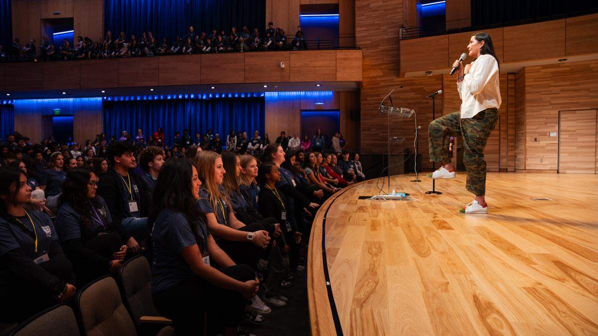 Dr. Lori Atkins of Bumble Bee Yoga leads more than 1,000 North Texas students in a stretch break. The students convened in Arlington on Wednesday, Jan. 15, 2025 for the Peer-to-Peer Youth Conference, bringing together students to address youth mental health.