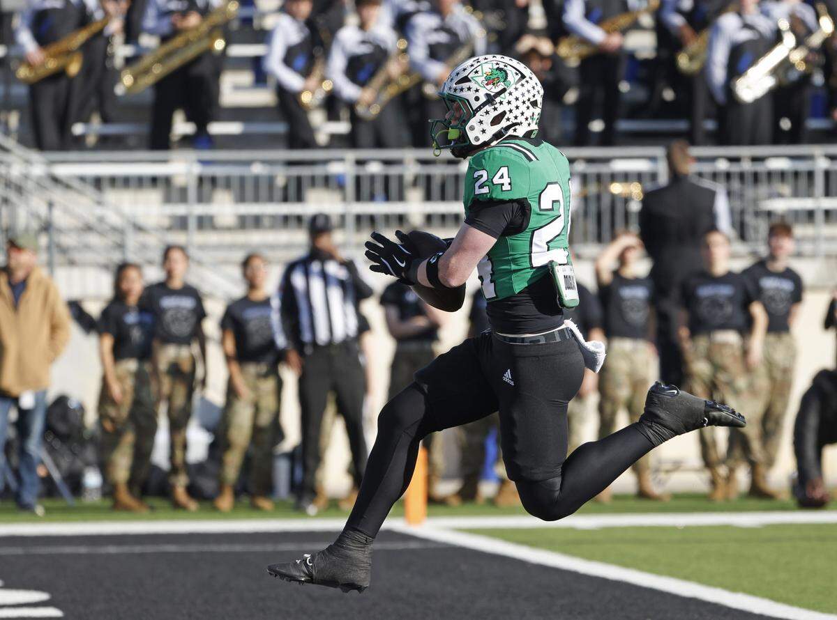 Southlake Carroll running back Brooks Biggers (24) leaps into the end zone for a touchdown against Denton Guyer during the first half of a UIL Class 6A Division II Quarterfinal on Saturday Dec. 06, 2025 at Crowley ISD Multi-Purpose Stadium in Fort Worth, Texas.