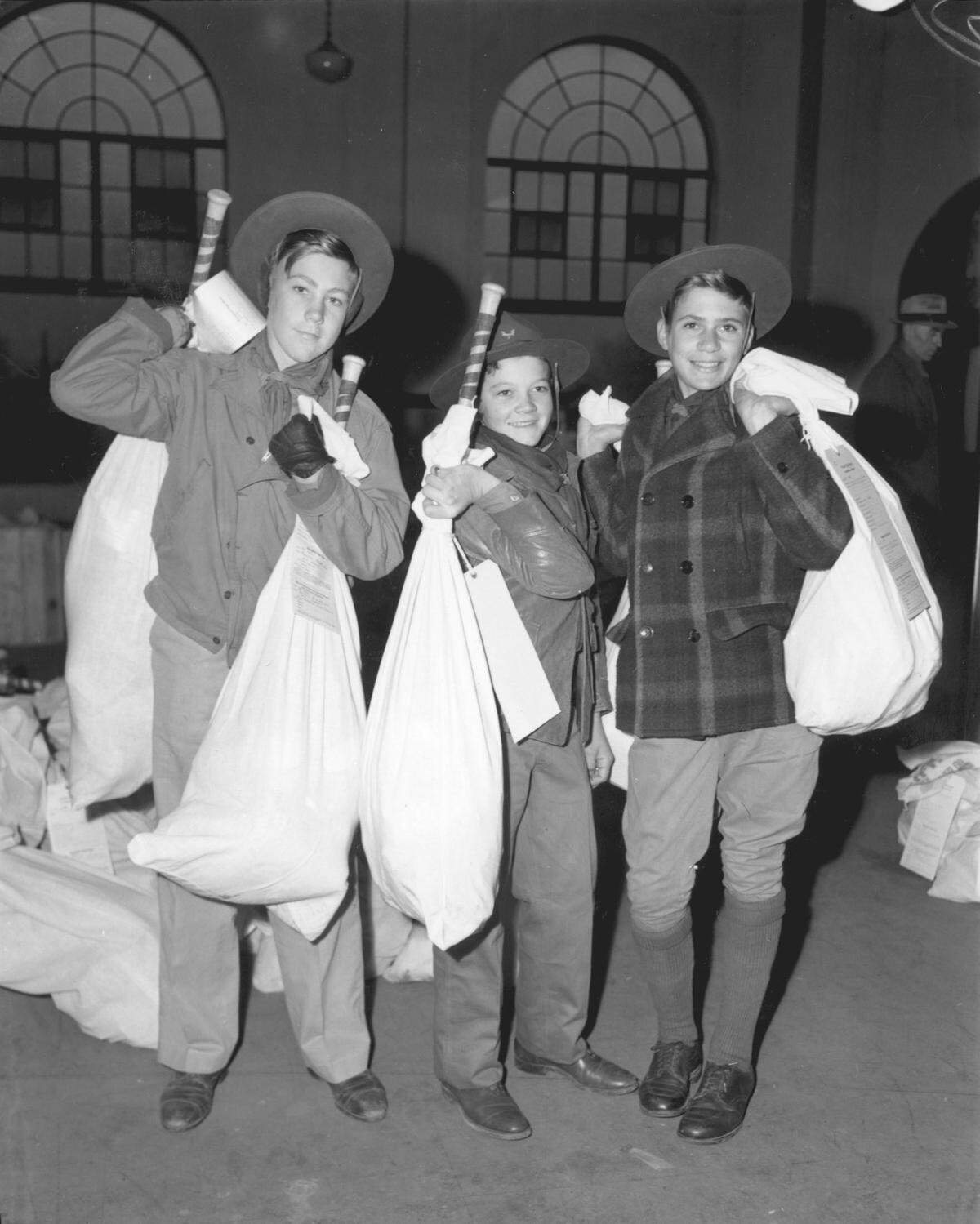 Dec. 23, 1944: Boy Scouts Harold Wayland, left, Clifford Yeldell and Guy Guyette of Troop 22 shoulder Goodfellow bundles of Christmas presents before loading them on a waiting truck.
