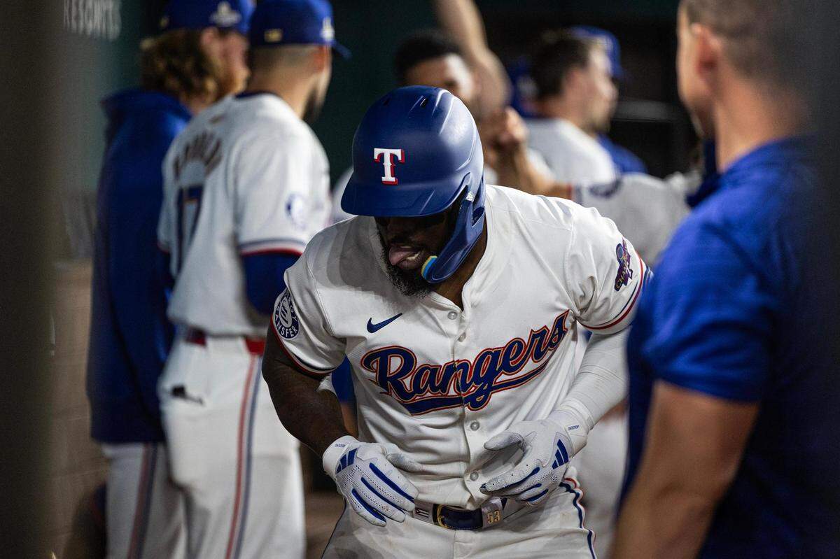 Texas Rangers outfielder Adolis Garcia (53) celebrates in the dugout after hitting his first home run of the season in the sixth inning of the season opener against the Chicago Cubs at Globe Life Field in Arlington on Thursday, March 28, 2024.