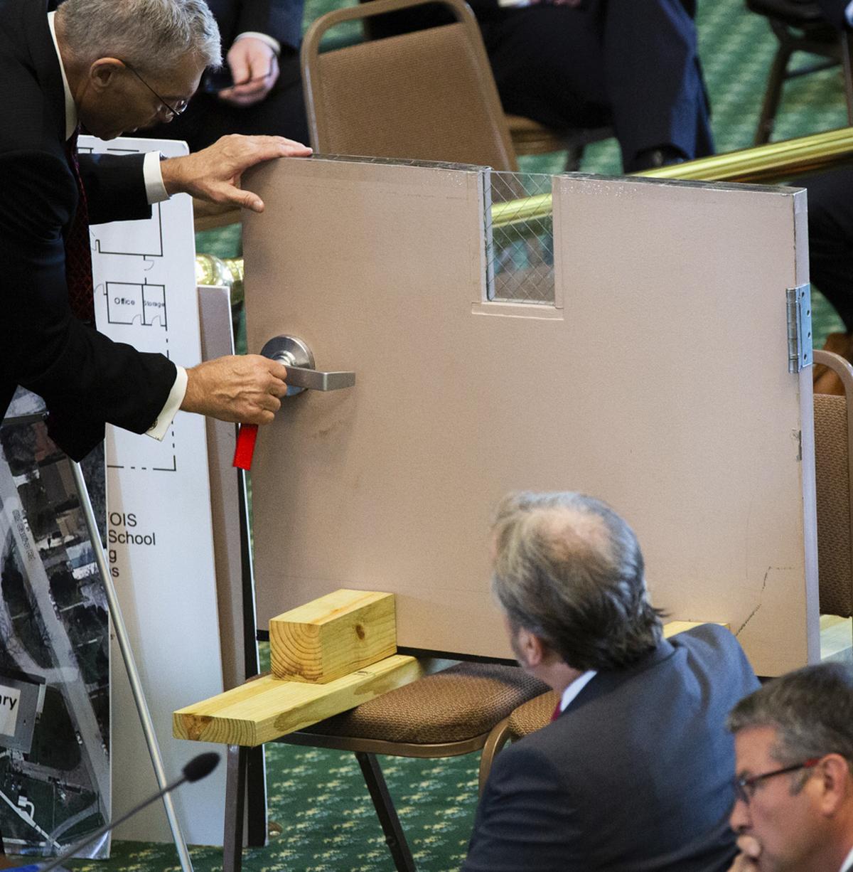 Texas Department of Public Safety Director Steve McCraw shows how an interior door in Robb Elementary School failed to lock securely to the Texas Senate Special Committee to Protect All Texans during the hearing at the Texas State Capitol in Austin, Tuesday, June 21, 2022. The hearing was held to examine the recent school shooting at Robb Elementary in Uvalde, Texas. (Sara Diggins/Austin American-Statesman via AP)