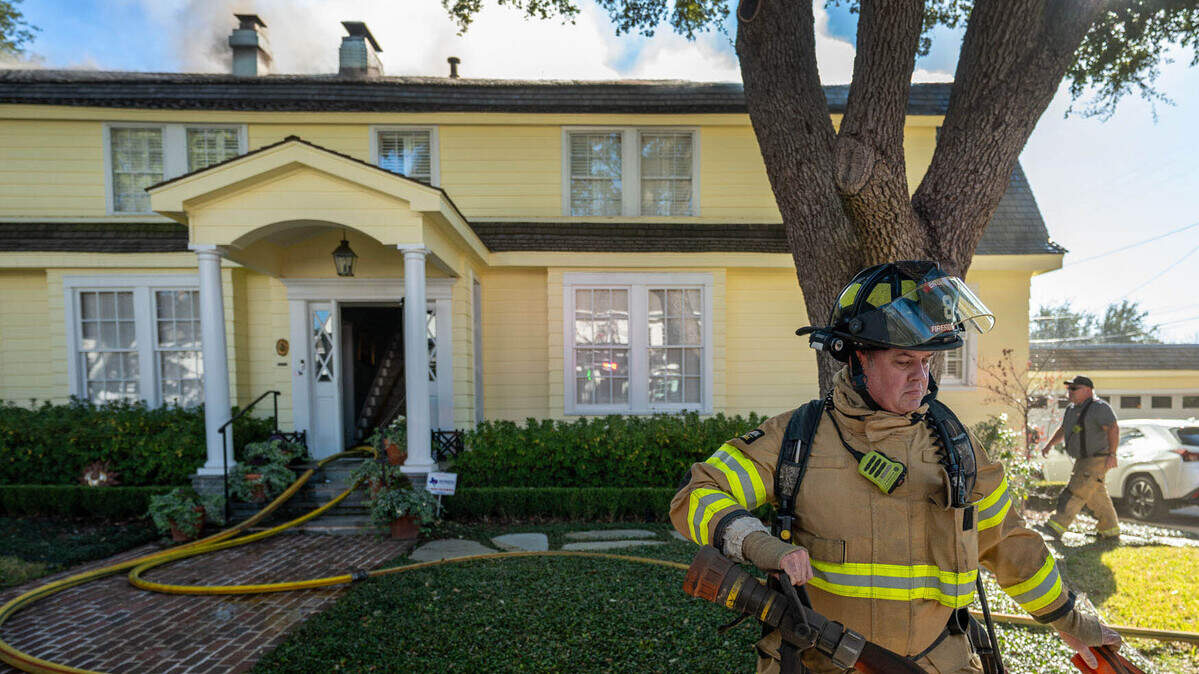 A Fort Worth firefighter works to contain a house fire in a historic home in the 1800 block of Western Avenue on Jan. 6, 2026.