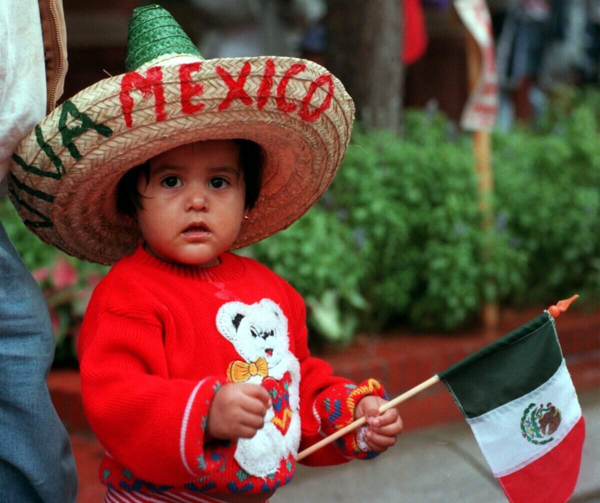 Sept. 12, 1998: In spite of the rain, Illana Olalde, 2, of Fort Worth, watches the El Dieciseis de Septiembre parade in downtown Fort Worth, sponsored by the Mexican Independence Day Parade Committee.