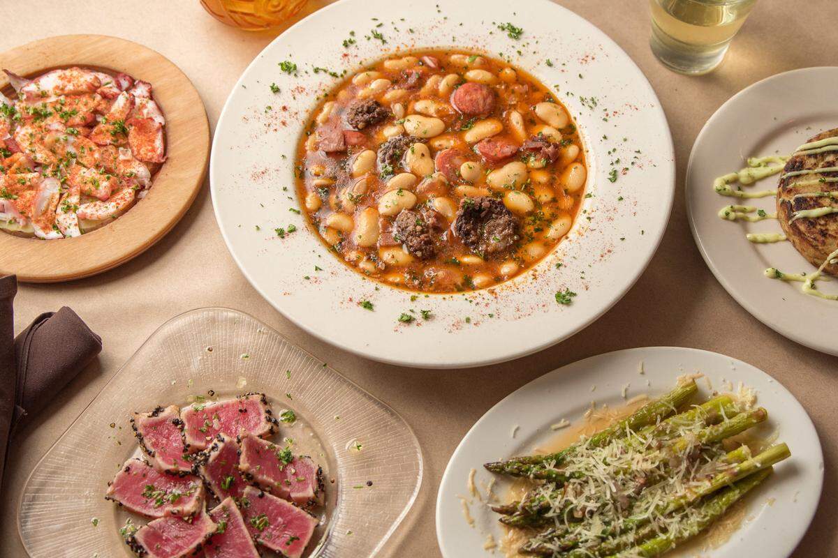 Plates of Si Tapas dishes which are pulpo a la gallega, fabada asturiana, atun a la plancha and asparagus.