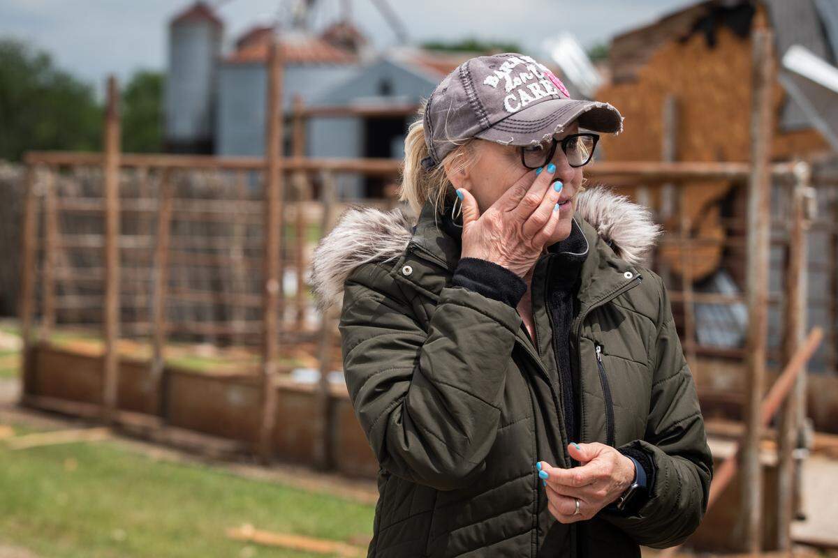 Cathy Haley wipes away tears while looking over damage caused by a tornado Tuesday, May 4, 2021, at Barn on the Brazos in Blum.