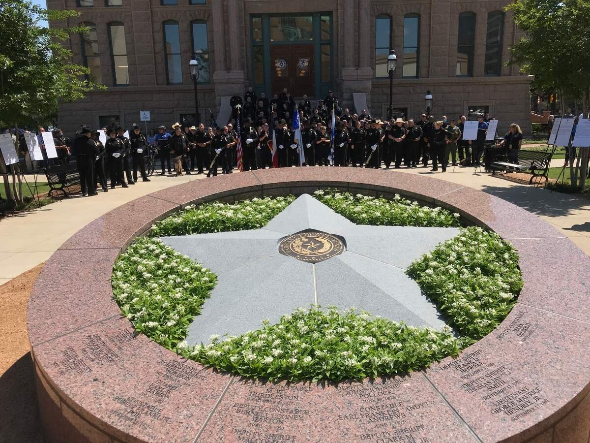 Dozens of Tarrant County, TX law enforcement officials face the newly unveiled Law Enforcement Memorial outside of the 1895 Courthouse. The names of 16 fallen officers grace the memorial.