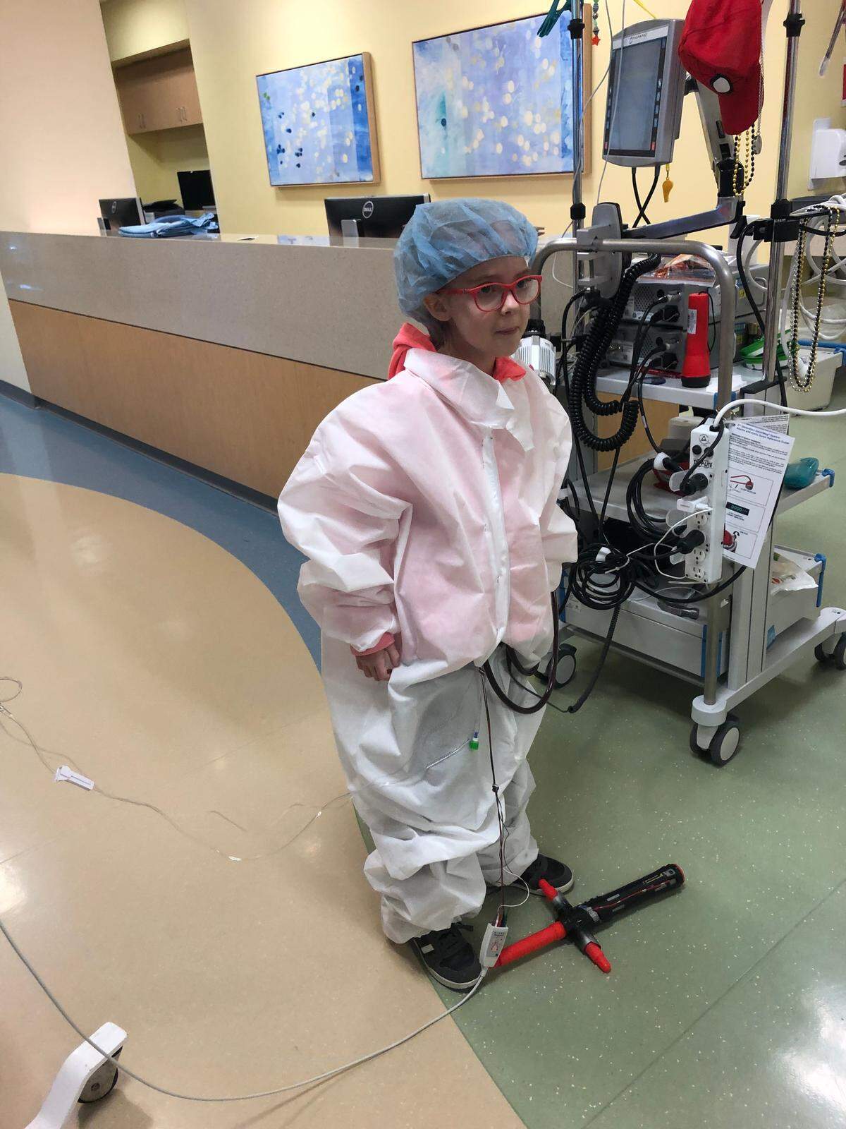 Riley Robinson stands in the hallway of Children’s Medical Center Dallas with a toy lightsaber underneath her feet. As she awaited her heart transplant for several months, she liked to play games with staff members like lightsaber duels.