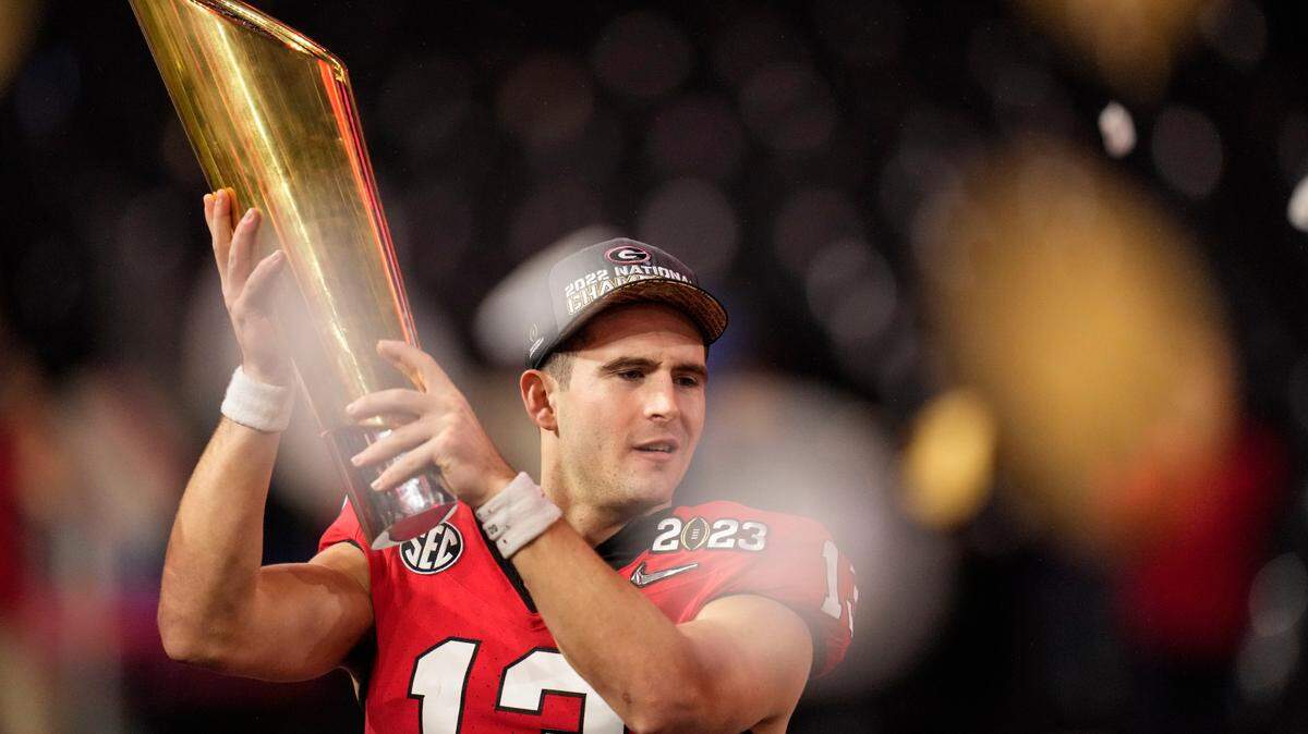 Georgia quarterback Stetson Bennett (13) holds the championship trophy after the national championship NCAA College Football Playoff game against TCU, Monday, Jan. 9, 2023, in Inglewood, Calif. Georgia won 65-7.