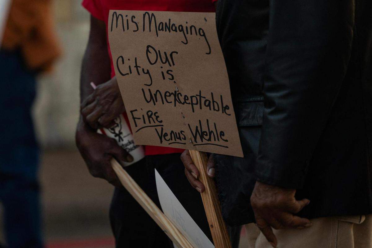 Forest Hill residents hold signs in support of their police chief, Eddie Burns Sr., who was fired in February after being on medical leave for months before his termination, in front of Forest Hill City Hall on Friday, March 1, 2024.