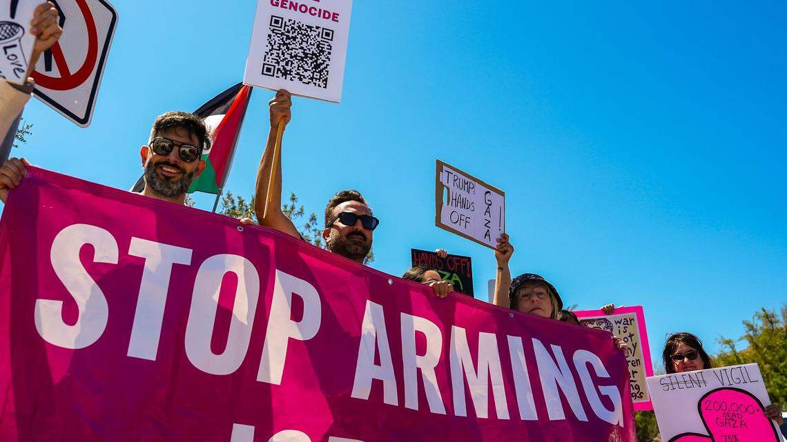 Abraham Ishaq (left) of Palm Springs, helps to hold up a large banner in opposition to military aid to Israel during the Hands Off protest near city hall in Rancho Mirage, Calif., Saturday, April 5, 2025.
