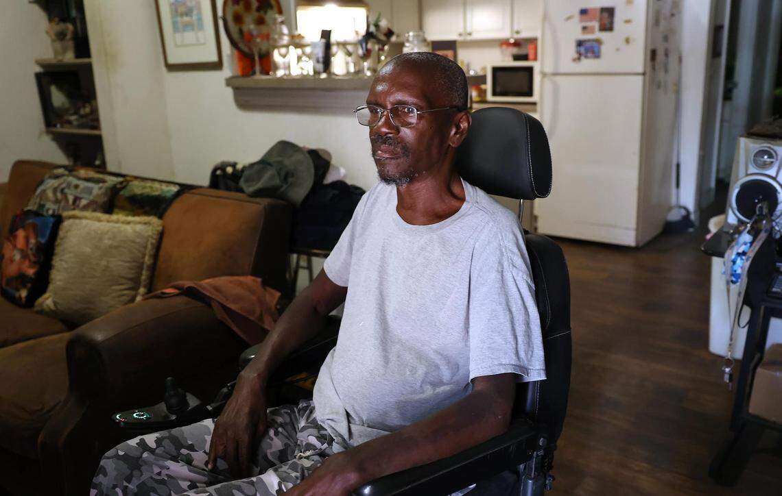 Willie Miller, Robert Miller's father, sits in his wheelchair inside of his Fort Worth townhome living room.