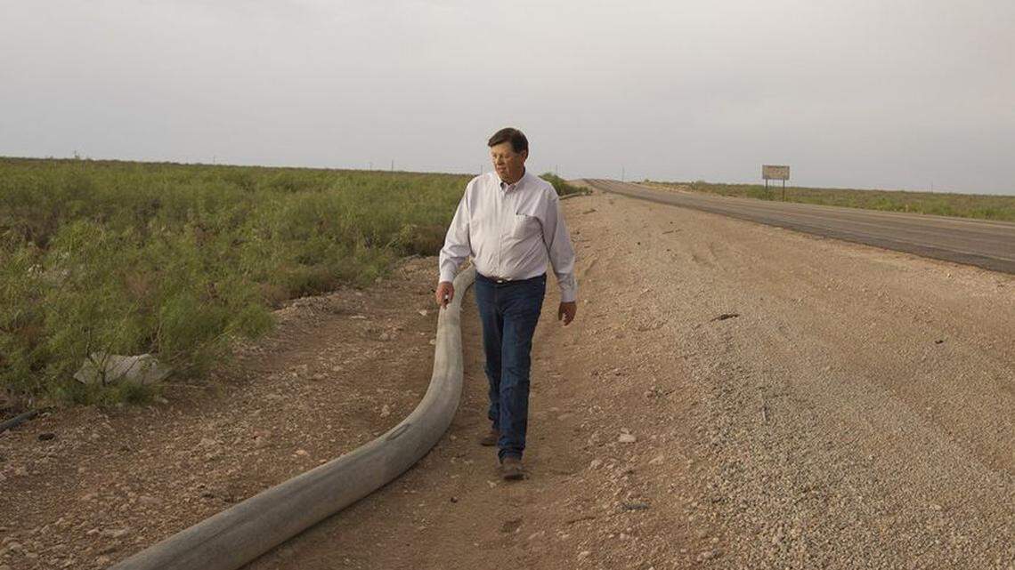 New Mexico State Land Commissioner Aubrey Dunn walks along Ranch Rd 652 at the Texas-New Mexico border on May 23, 2018, next to a water line that runs from Loving County, Texas, to Lea County, New Mexico.