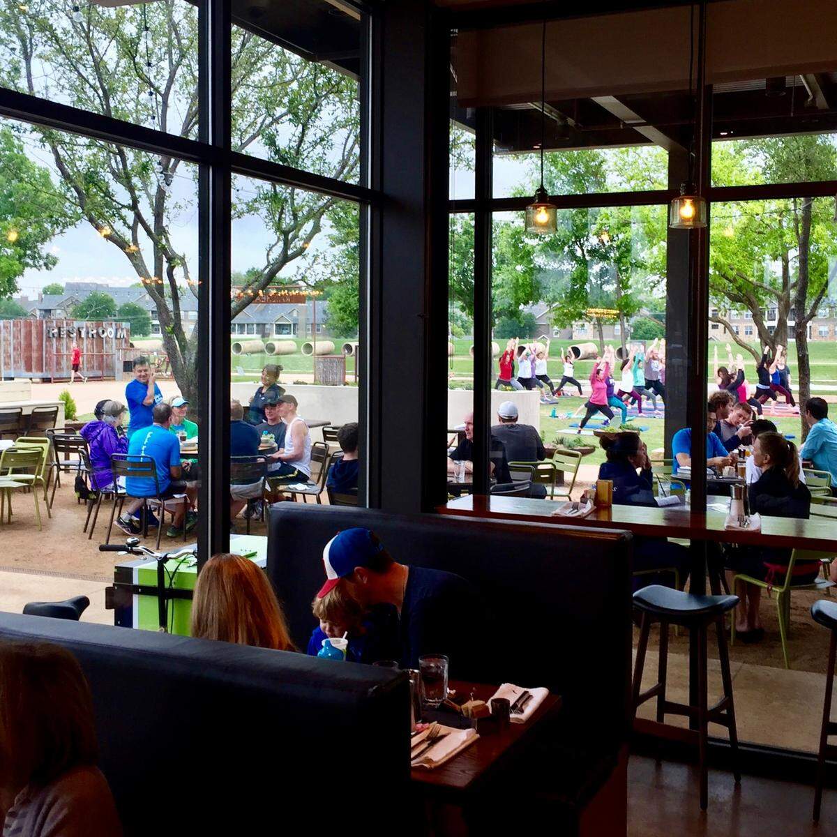 A dining room at Press Cafe in Fort Worth overlooks the patio and Trinity Trail.