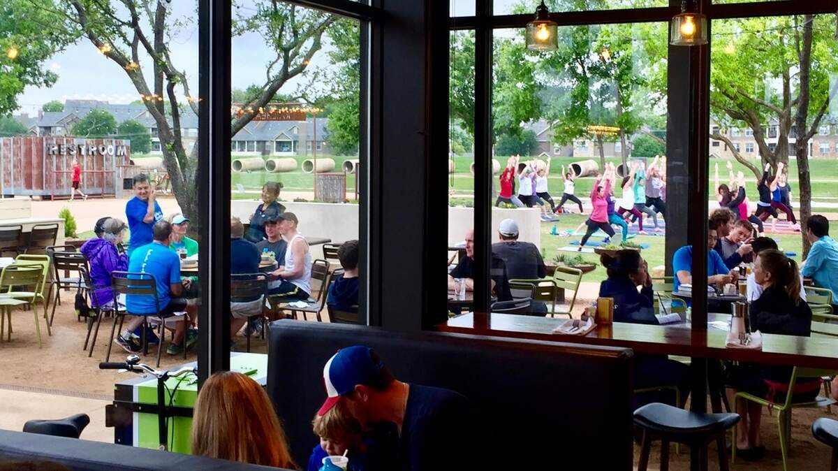 A dining room at Press Cafe in Fort Worth overlooks the patio and Trinity Trail.