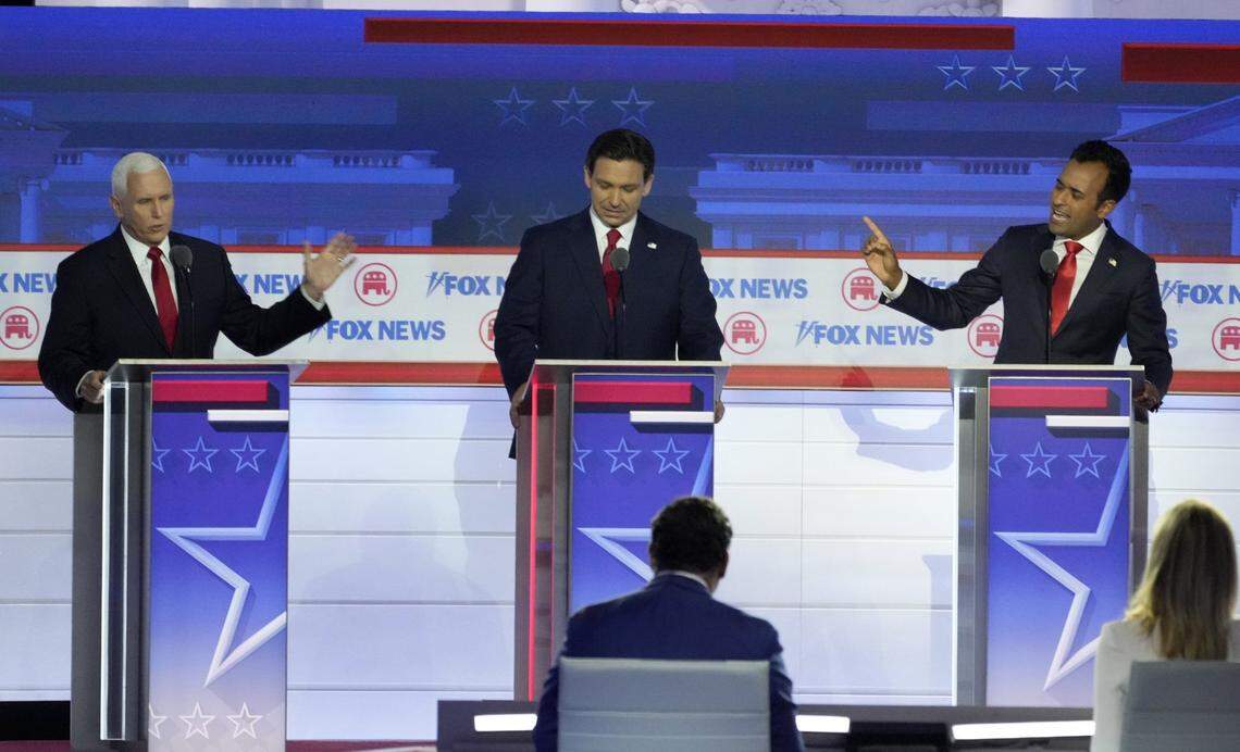 Aug 23, 2023; Milwaukee, WI, USA; Republican presidential candidate former Vice President Mike Pence (left) and Republican presidential candidate Biotech entrepreneur Vivek Ramaswamy argue a topic as Republican presidential candidate Florida governor Ron DeSantis listens in at Fiserv Forum during the first 2023 Republican presidential debate. Mandatory Credit: Mike De Sisti-USA TODAY NETWORK