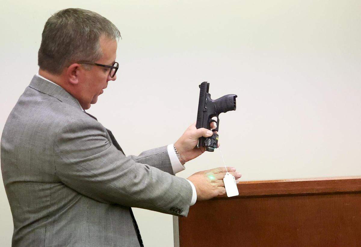 Defense attorney Miles Brissette demonstrates how the green laser on the weapon owned by Atatiana Jefferson works on Tuesday, December 13, 2022, in Fort Worth during the murder trial of Aaron Dean. Both sides have rested and closing arguments will begin Wednesday morning.