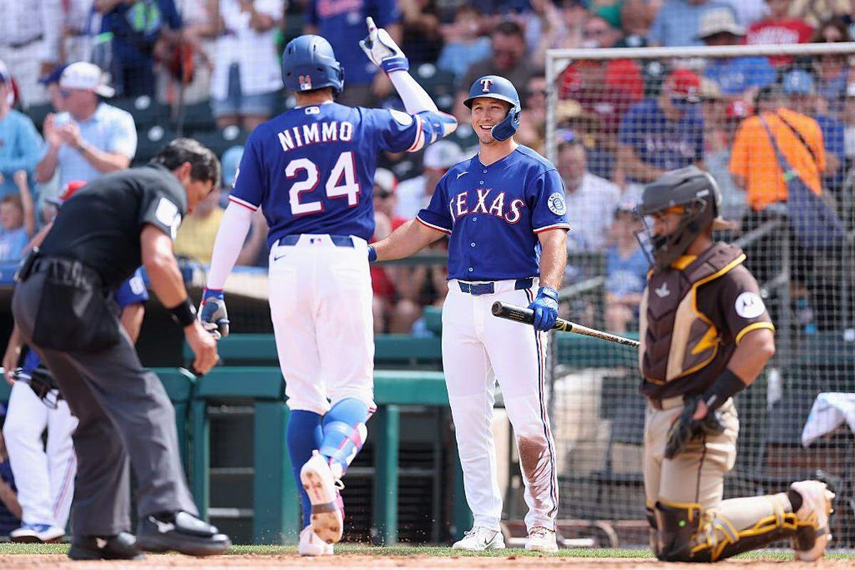 Wyatt Langford #36 of the Texas Rangers congratulates Brandon Nimmo #24 after hitting a solo home run against the San Diego Padres during the second inning of the spring training game at Surprise Stadium on March 14, 2026 in Surprise, Arizona