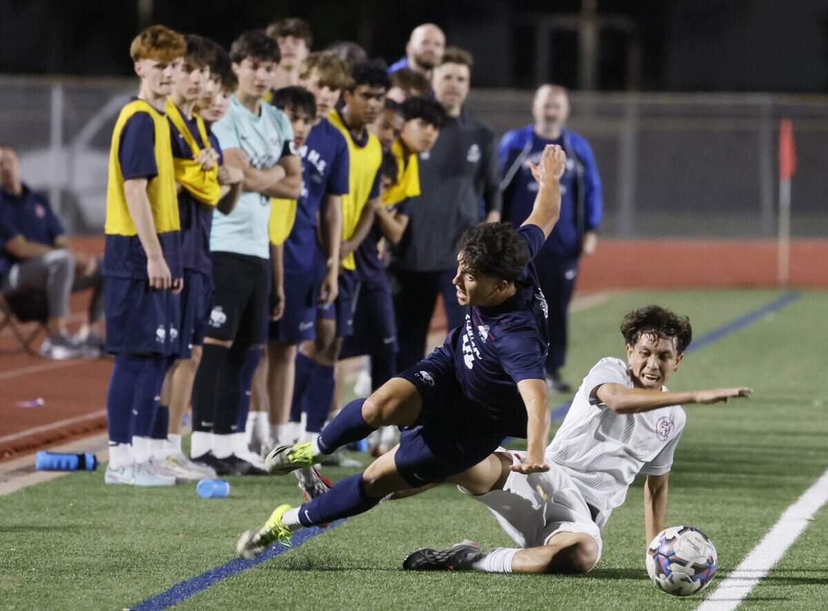 Allen midfielder James Mastrangelo (10) and Arlington Sam Houston David Alejo (6) go down in front of the Allen bench during the first half of a UIL area round boys soccer playoff game at Tommy Standridge Stadium in Carrollton, Texas, Tuesday, March 24, 2026.