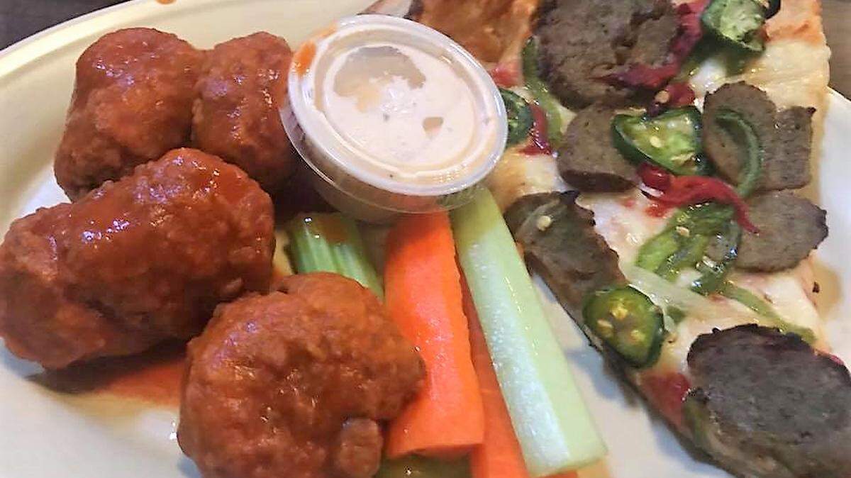Four wings with "suicide" sauce and a slice of New Yorker pizza at Buffalo Bros. Pizza, Wings and Subs.