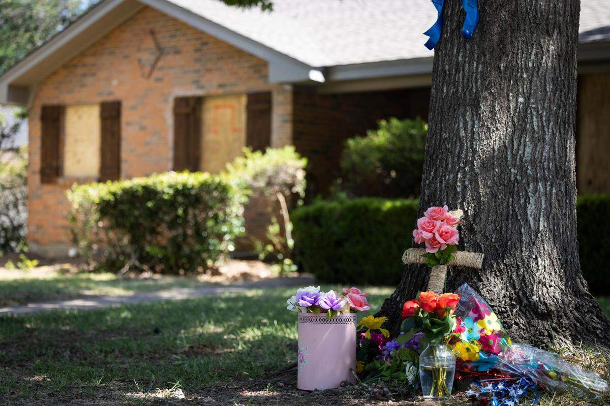 A memorial is set up Tuesday, July 5, 2022, in front of the house where Saturday’s shooting killed two people in Haltom City. The gunman also shot and wounded three police officers and a woman who lives across the street before killing himself, authorities said.