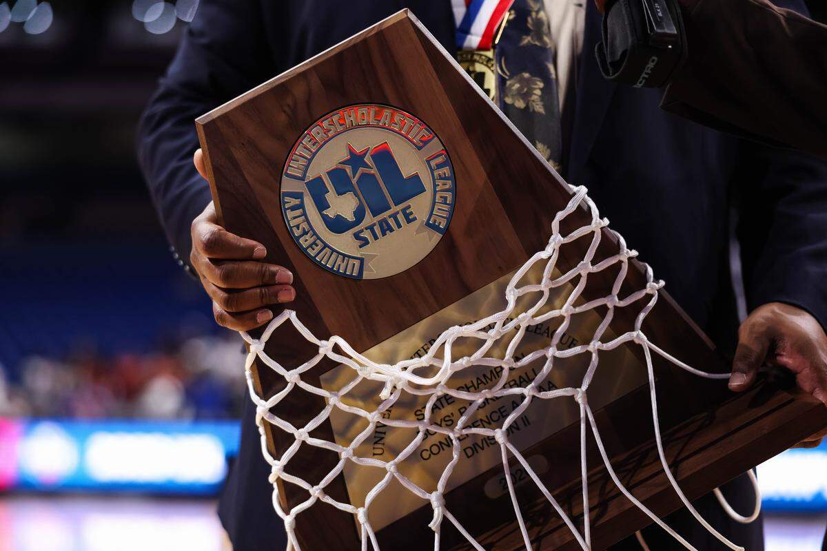 Mansfield Summit head coach Emund Prichett holds the championship trophy after the Class 5A Division II state championship game against Beaumont United on Saturday at the Alamodome in San Antonio.