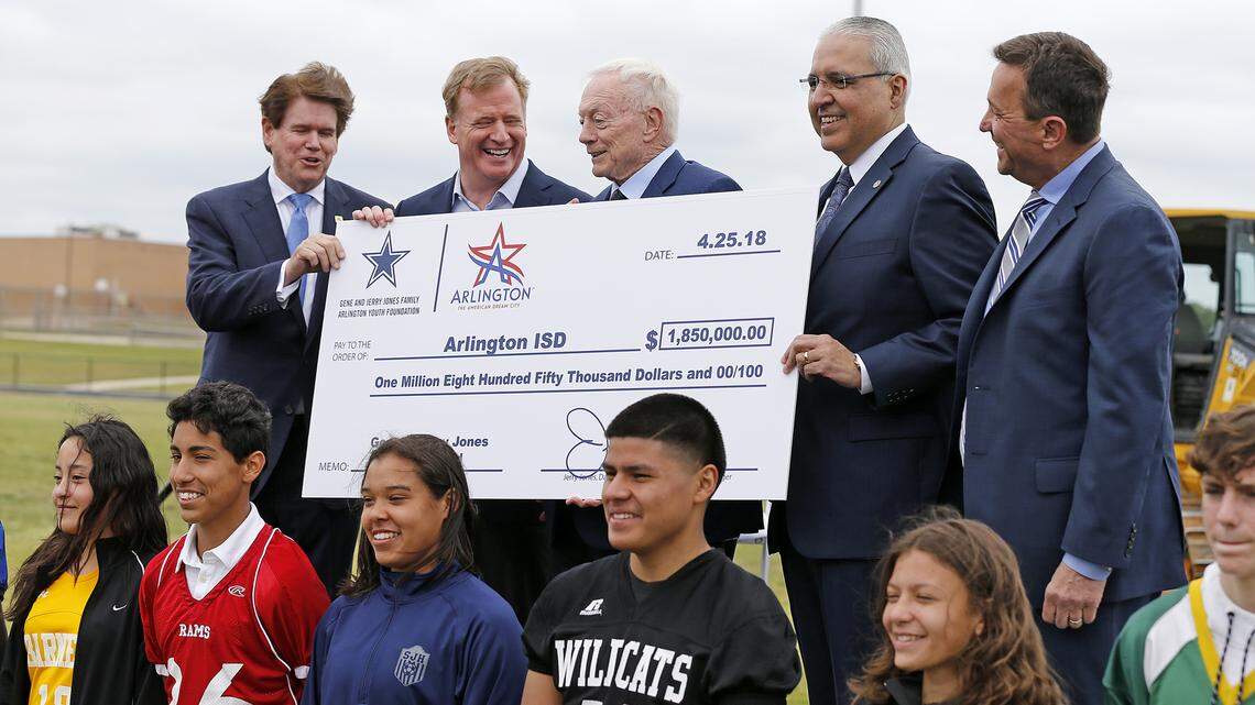 Dallas Cowboys owner Jerry Jones, middle, and NFL Commissioner Roger Goodell (left of Jones) help present a check for $1.85 million to the Arlington school district, Wednesday April 25, 2018.