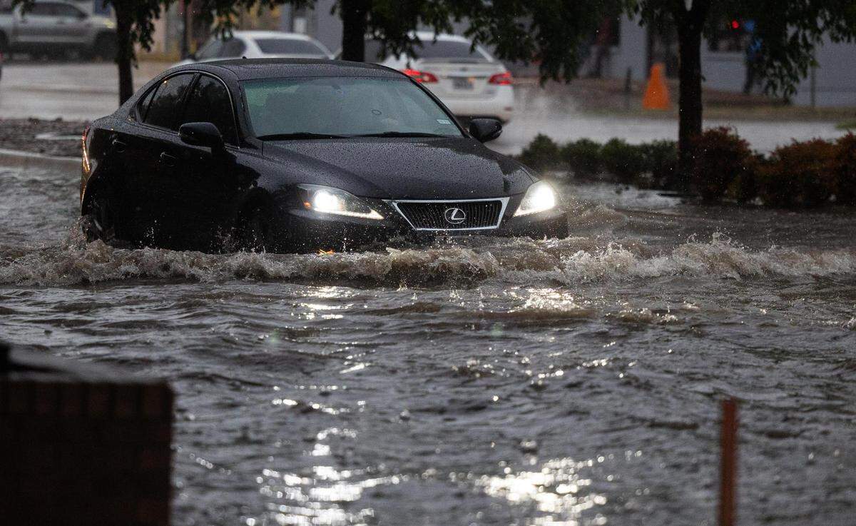 A car drives through a flooded area on Rosedale Street near Hemphill during a heavy rainstorm Monday, Aug. 22, 2022, in Fort Worth.