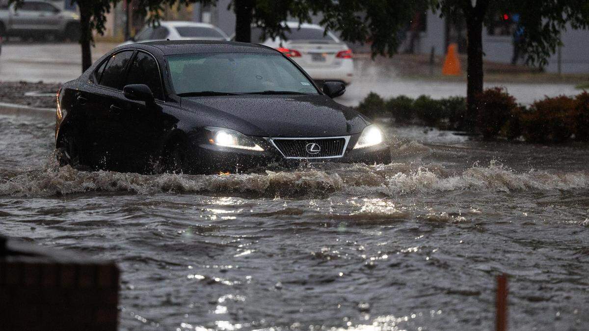 A car drives through a flooded area on Rosedale Street near Hemphill during a heavy rainstorm Monday, Aug. 22, 2022, in Fort Worth.