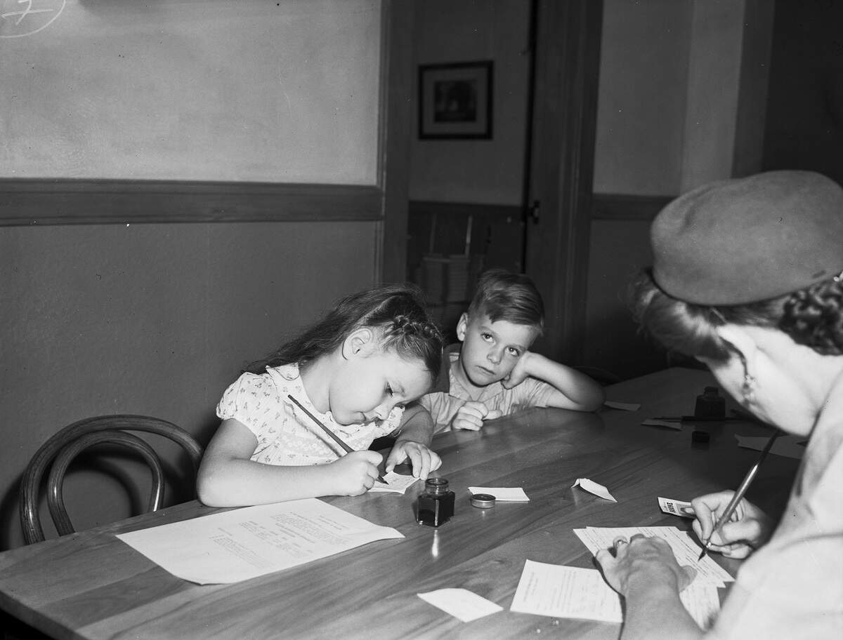 Sept. 11, 1945: Second-graders Mary Fides McKee and Benny Smith are shown acting differently to the first day of school. Mary is trying out a pen, while Benny appears bored with it all.