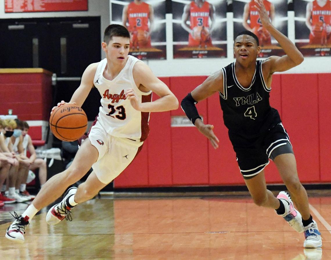 Argyle’s Eli Valentino, left, takes the ball up the court past Young Men’s Learning Academy’s D’Monyae Davis during the second period of their 4A Region I Quarterfinal playoff game Saturday, February 27, 2021 at Colleyville Heritage High School in Colleyville, Texas. Argyle went on to win 49-40. Special/Bob Haynes